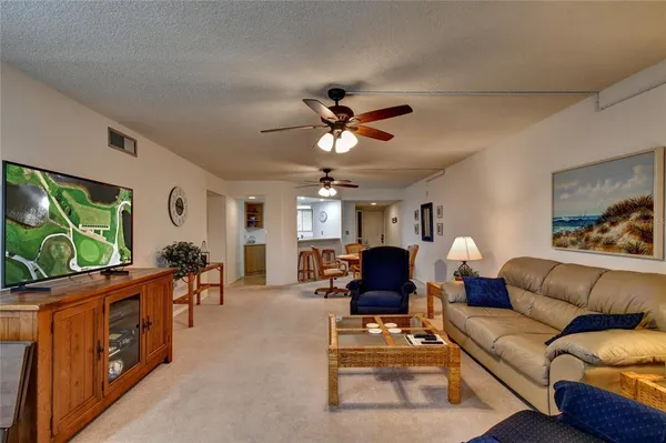 a living room with furniture a flat screen tv and a large window