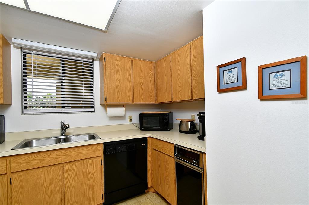 601 Islamorada Boulevard, Unit 24B Punta Gorda, FL 33955 - Photo 9 of 36 a kitchen with a sink cabinets and window