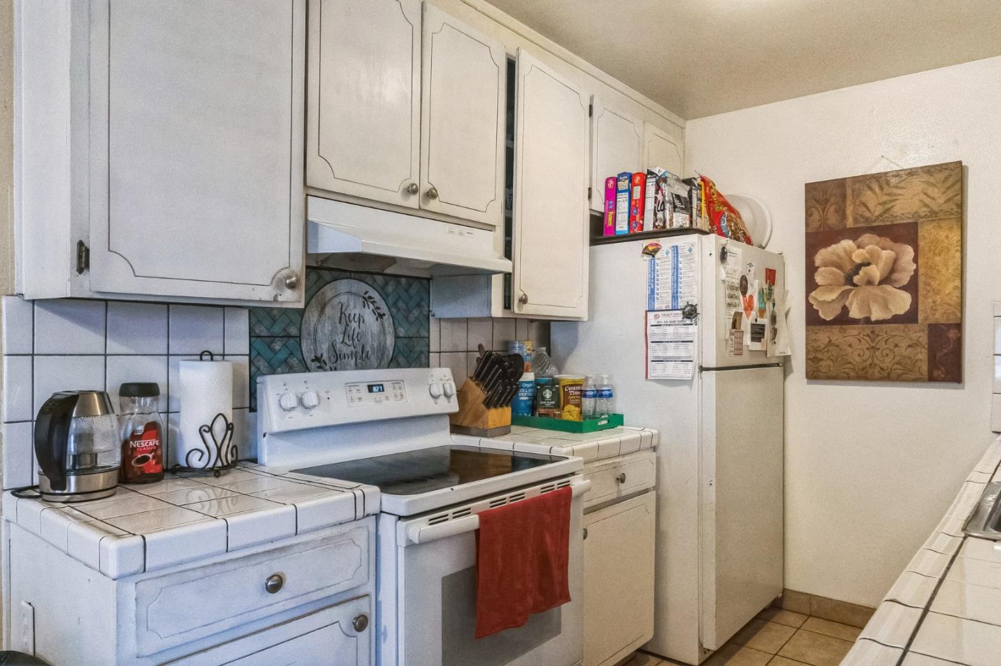 708 Sequoia Boulevard Tracy, CA 95376 - Photo 4 of 14 a kitchen with a refrigerator and white cabinets