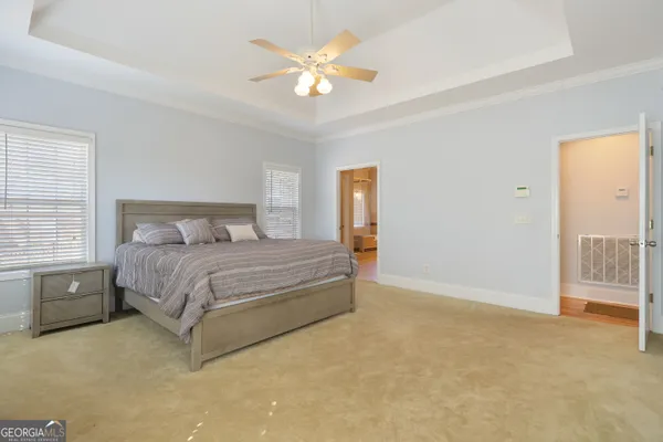 a en suite bathroom with a granite countertop double vanity sink and a large mirror