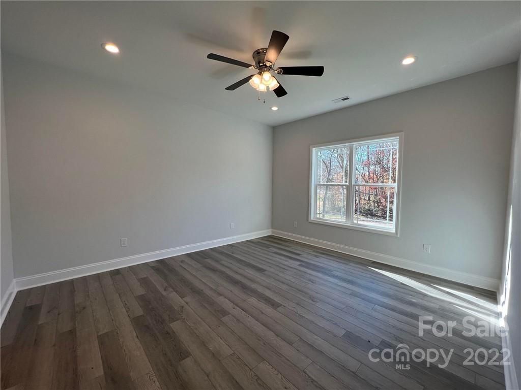 508 Willow Road Salisbury, NC 28147 - Photo 5 of 17 an empty room with wooden floor ceiling fan and windows