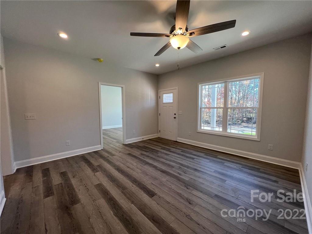 508 Willow Road Salisbury, NC 28147 - Photo 9 of 17 an empty room with wooden floor chandelier fan and windows