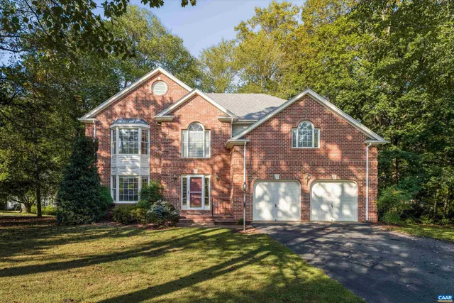 a view of a big house with a big yard and large trees