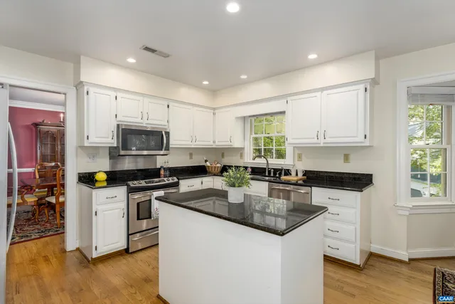 a kitchen with granite countertop a sink a counter top space appliances and cabinets