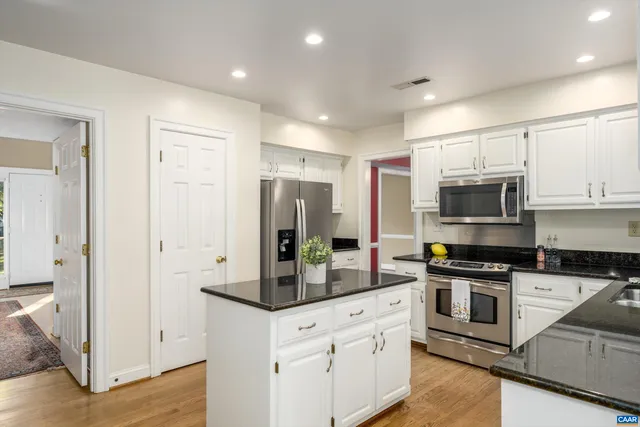 a kitchen with stainless steel appliances granite countertop a refrigerator and a stove top oven