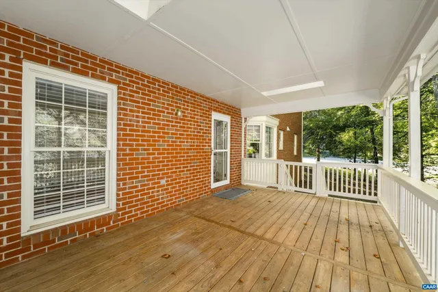 a view of a porch with wooden floor and fence