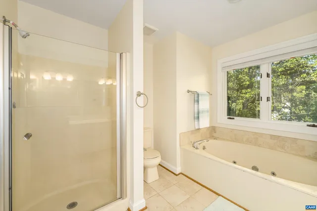 a bathroom with a bathtub shower and toilet
