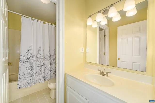 a bathroom with a granite countertop sink and a bathtub