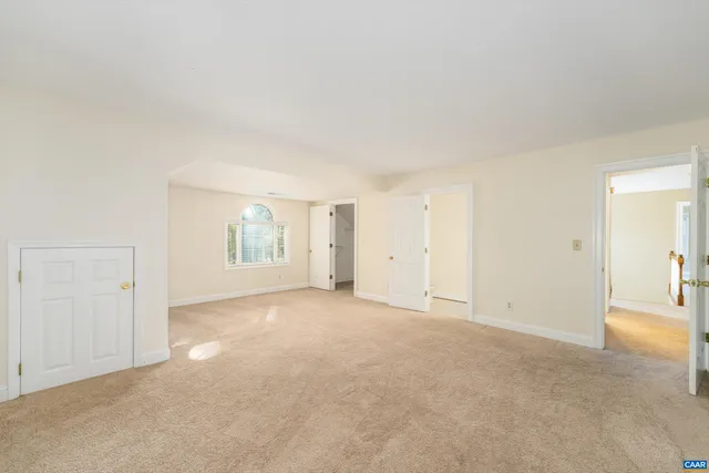 an empty room with windows and bathroom view
