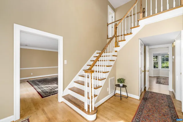 a view of entryway bedroom and hall with wooden floor