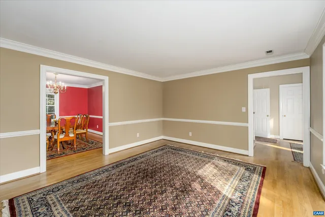 a view of a bedroom with wooden floor and a rug