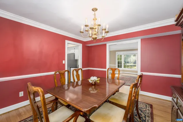 a view of a dining room with furniture a chandelier and wooden floor