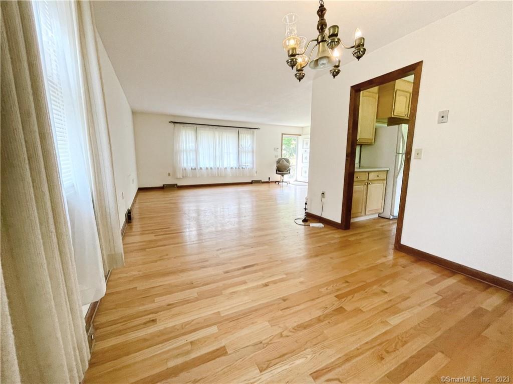 a view of a room with wooden floor and ceiling fan