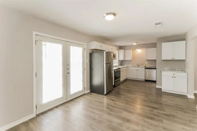 a kitchen with stainless steel appliances granite countertop a refrigerator and a stove top oven