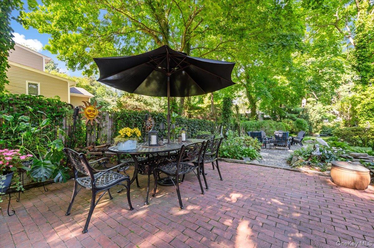 10 Rancher Place Huntington, NY 11743 - Photo 35 of 44 Expansive brick paver patio featuring a dining area under a large umbrella