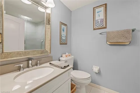 a bathroom with a granite countertop sink mirror vanity and toilet