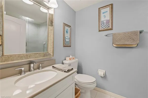a bathroom with a granite countertop sink mirror vanity and toilet