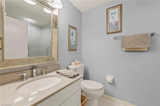 a bathroom with a granite countertop sink mirror vanity and toilet