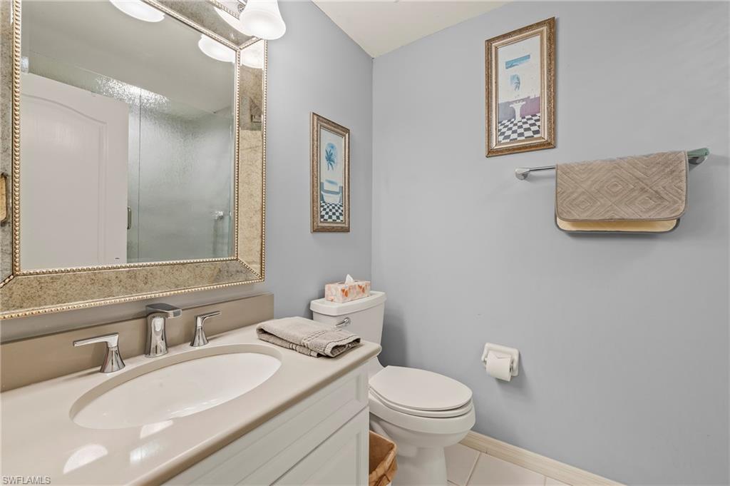 9300 Highland Woods Boulevard, Unit 3307 Bonita Springs, FL 34135 - Photo 11 of 43 a bathroom with a granite countertop sink mirror vanity and toilet