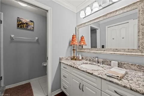 a bathroom with a granite countertop sink a mirror and a shower