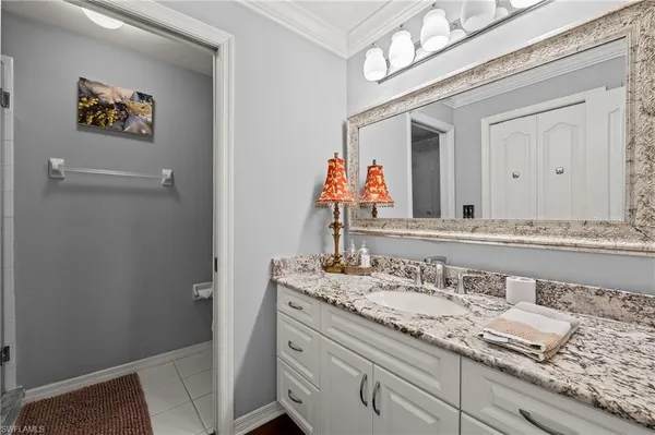 a bathroom with a granite countertop sink a mirror and a shower