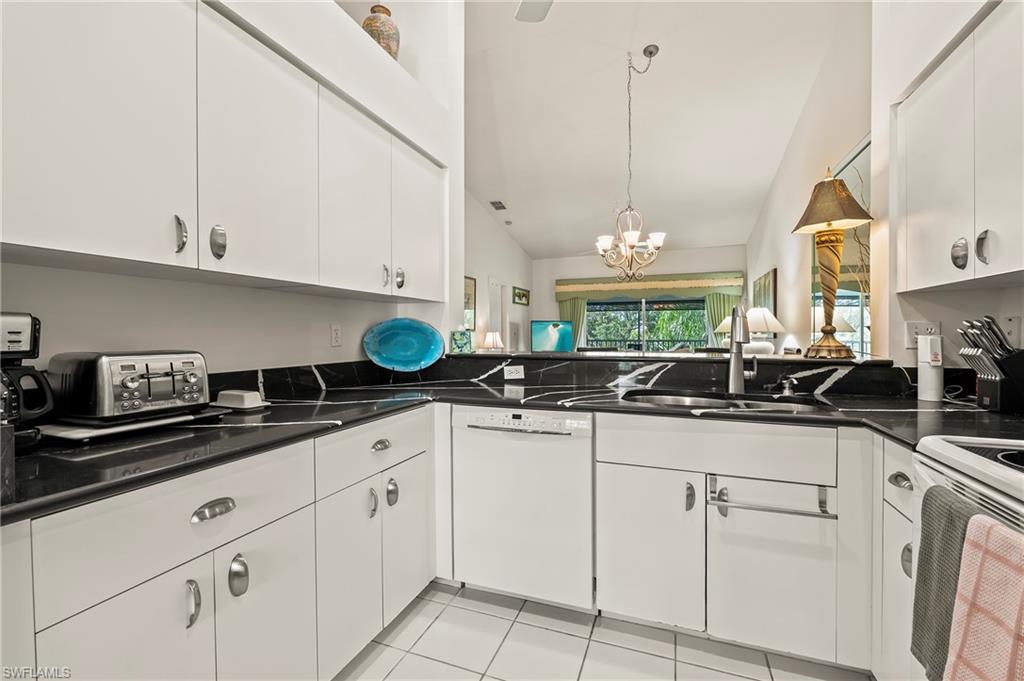 9300 Highland Woods Boulevard, Unit 3307 Bonita Springs, FL 34135 - Photo 4 of 43 a kitchen with white cabinets and white appliances