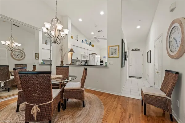 a dining room with wooden floor and chandelier