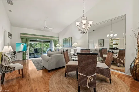 a living room with furniture chandelier and wooden floor