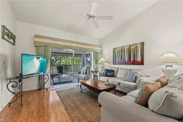 a living room with furniture a flat screen tv and wooden floor
