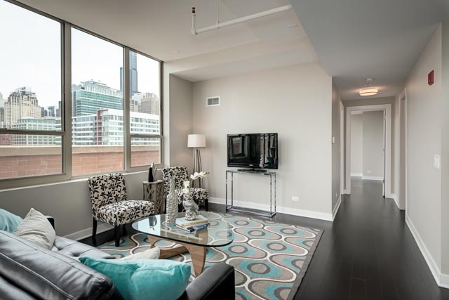 720 West Randolph Street, Unit PH7 Chicago, IL 60661 - Photo 2 of 18 a living room with furniture a flat screen tv and a large window