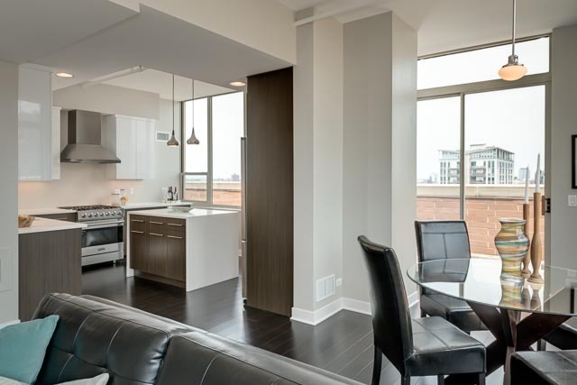 720 West Randolph Street, Unit PH7 Chicago, IL 60661 - Photo 4 of 18 a kitchen with stainless steel appliances granite countertop a stove top oven a sink dishwasher a dining table and chairs with wooden floor