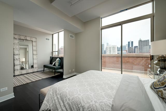 720 West Randolph Street, Unit PH7 Chicago, IL 60661 - Photo 10 of 18 a spacious bedroom with a bed and a large window
