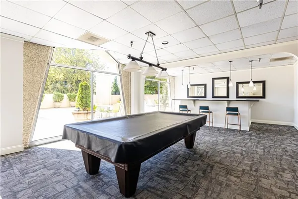 a room with pool table and windows