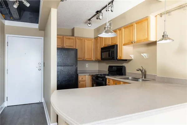 a kitchen with stainless steel appliances a stove microwave and sink