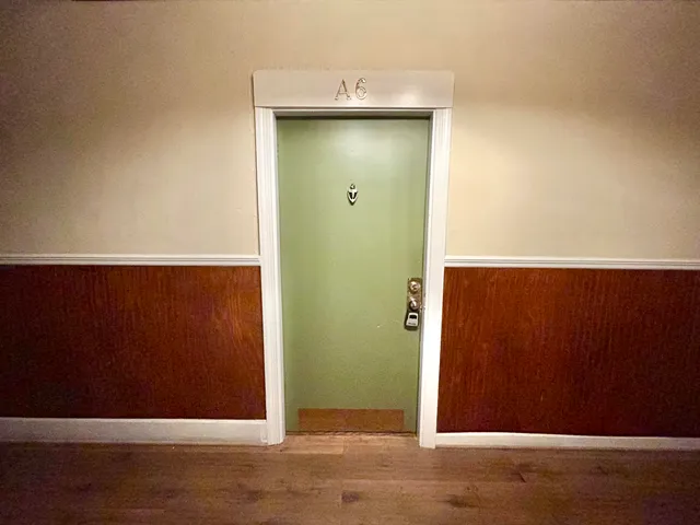 an empty room with wooden floor and cabinet