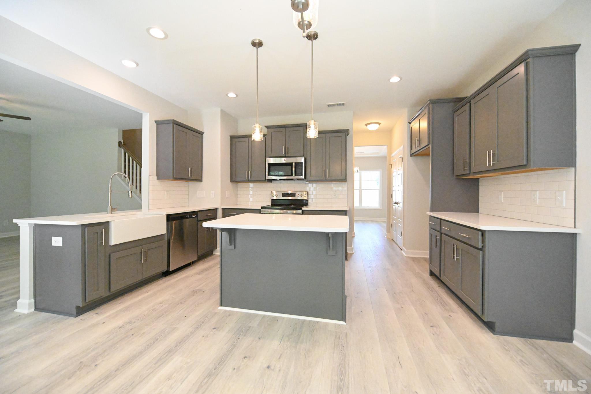11 Kevin Troy Court Angier, NC 27501 - Photo 11 of 35 a large kitchen with stainless steel appliances kitchen island granite countertop a refrigerator a stove a sink and a oven