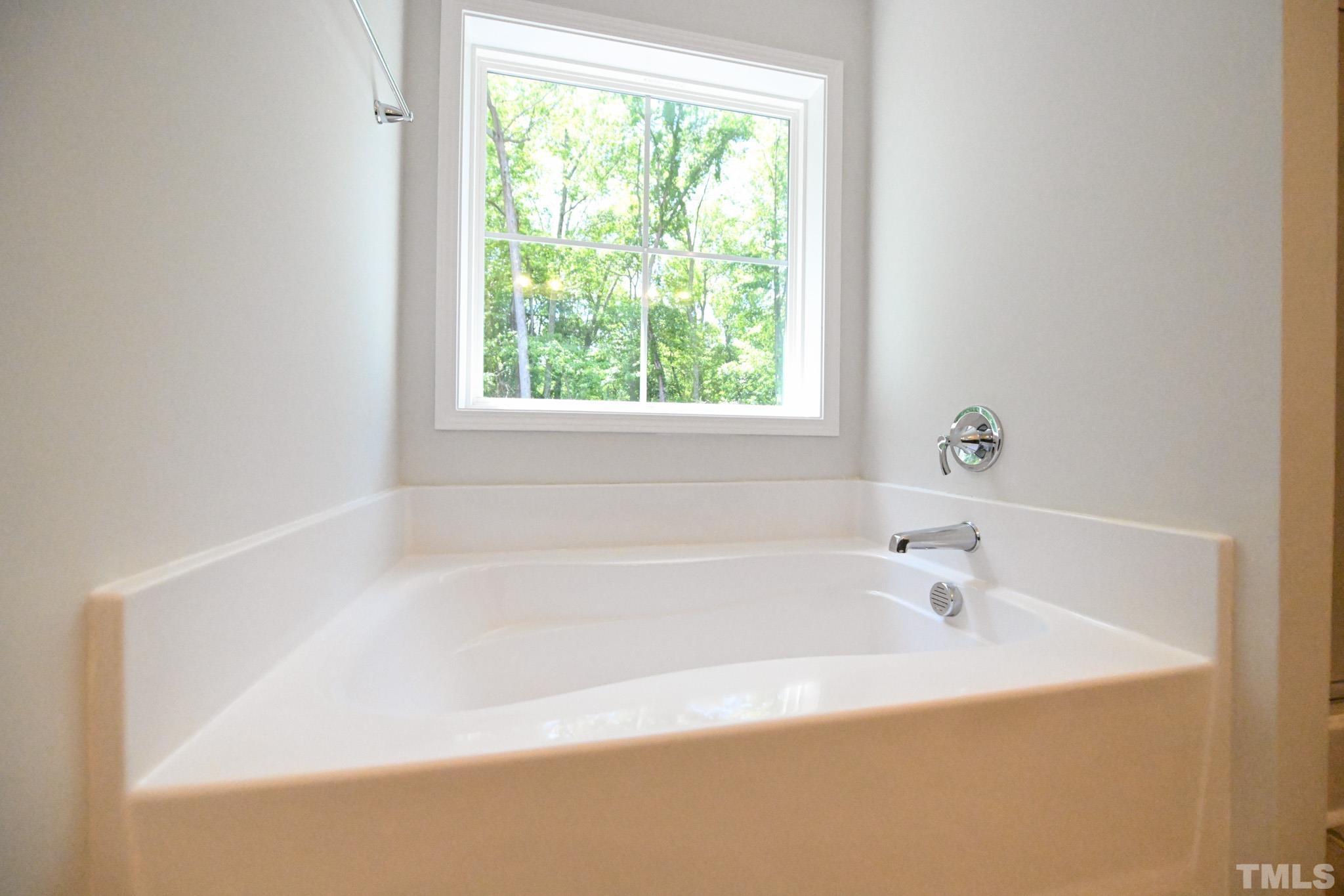 11 Kevin Troy Court Angier, NC 27501 - Photo 23 of 35 a white bath tub sitting in a bathroom next to a window