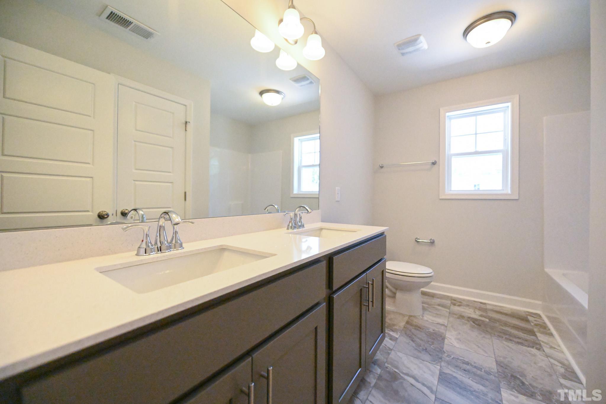 11 Kevin Troy Court Angier, NC 27501 - Photo 29 of 35 a bathroom with a sink a toilet and a mirror