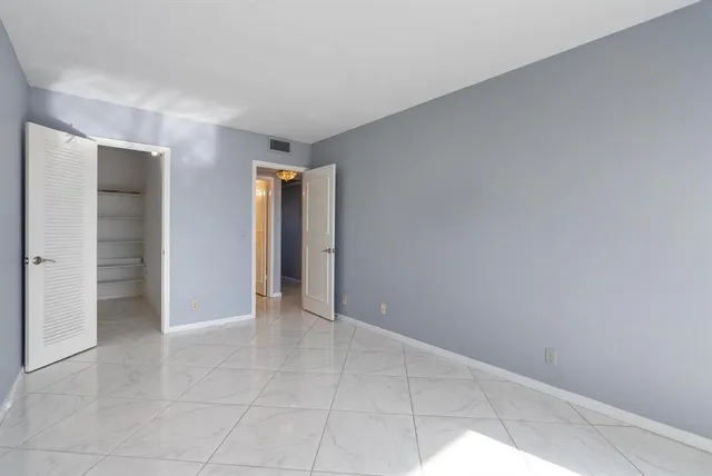 an empty room with closet and a bathroom