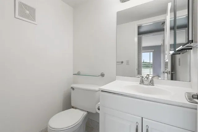 a bathroom with a sink a toilet and mirror