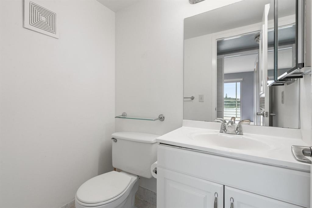 4036 Cornwall East, Unit 4036 Boca Raton, FL 33434 - Photo 16 of 30 a bathroom with a sink a toilet and mirror