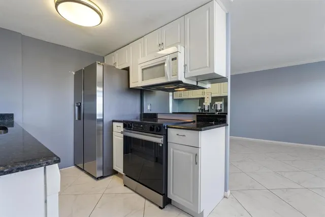 a kitchen with stainless steel appliances granite countertop a stove a microwave and a refrigerator