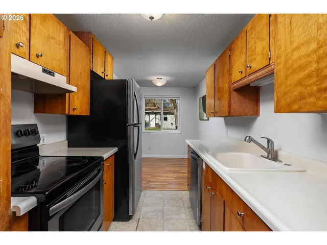 a kitchen with stainless steel appliances a sink cabinets and a refrigerator