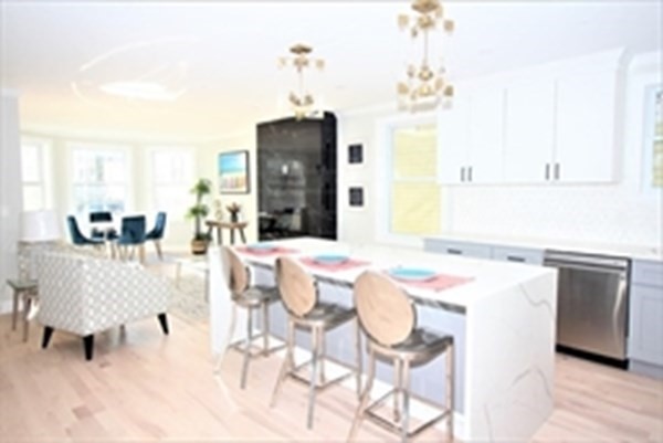 a dining room with kitchen island stainless steel appliances kitchen island granite countertop furniture and a chandelier