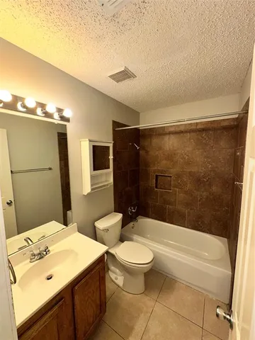 a bathroom with a bathtub shower sink vanity and toilet