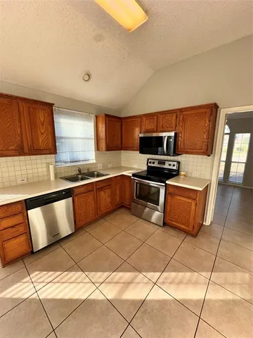 a kitchen with granite countertop a stove a sink and a microwave