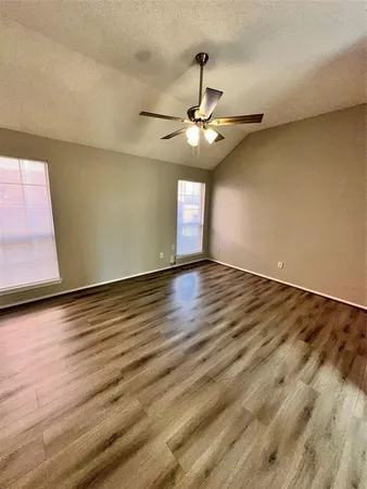 a view of an empty room with wooden floor