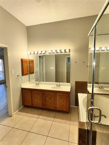 a bathroom with a tub sink and mirror