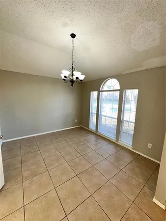 a view of an empty room with a chandelier