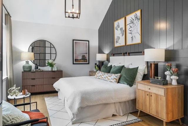 a bedroom with a bed and a dresser with mirror